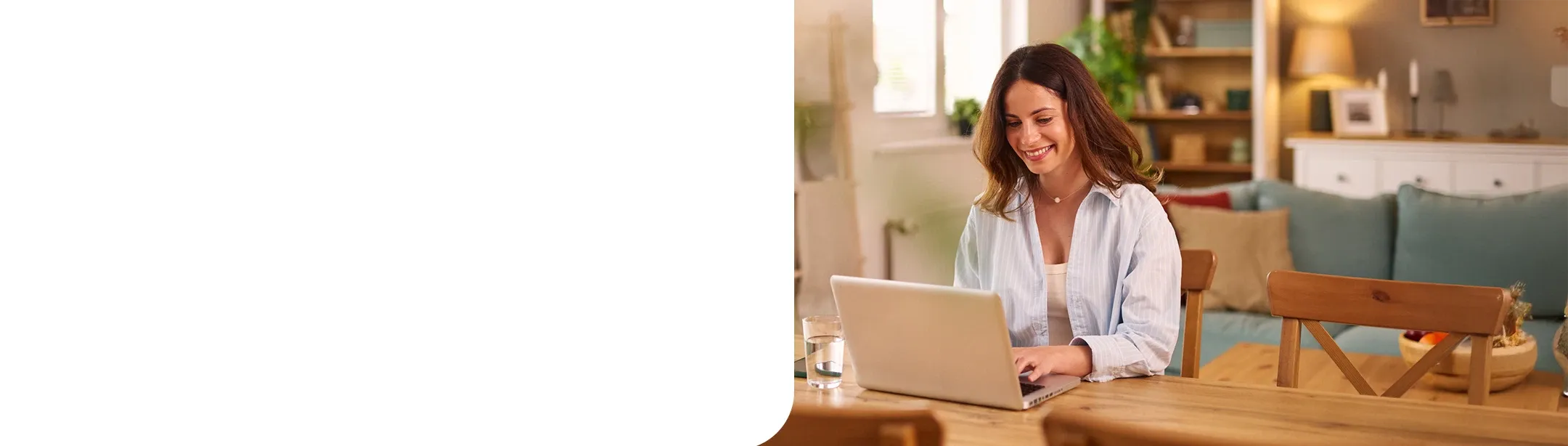 Woman working from home smiling and typing on laptop